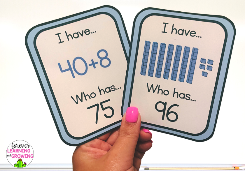 2 cards held up for an I have... Who Has game for place value to 99