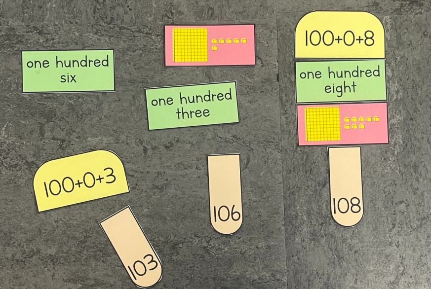 popsicle pieces on the ground showing numbers to 120 represented in different ways